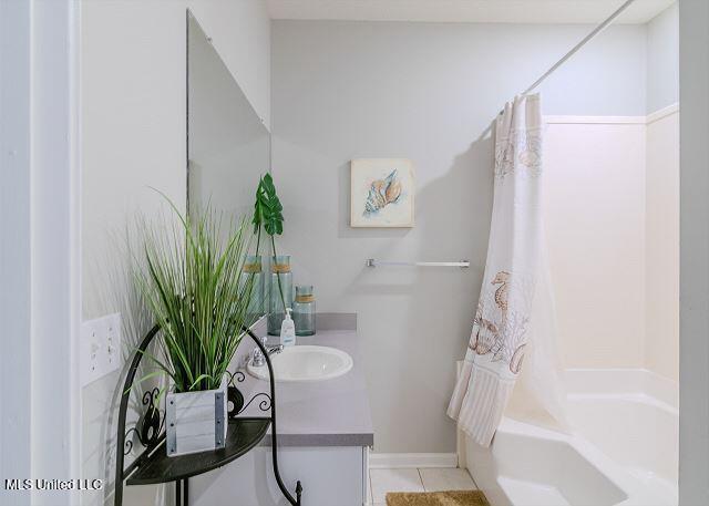 bathroom featuring tile patterned flooring, vanity, and shower / tub combo with curtain