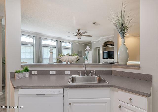 kitchen with white cabinets, ceiling fan, sink, and white dishwasher