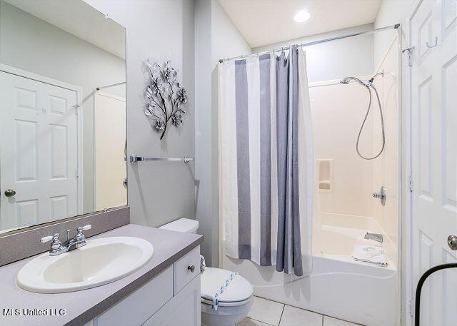 full bathroom with tile patterned floors, vanity, shower / bath combination with curtain, and toilet