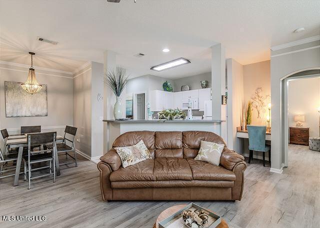 living room with crown molding and light hardwood / wood-style flooring