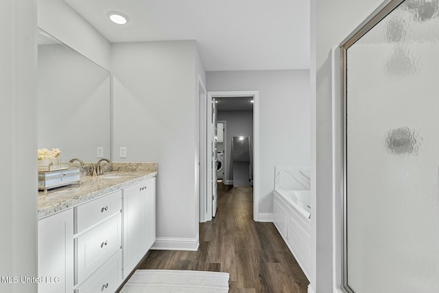 full bathroom featuring vanity, a garden tub, wood finished floors, and a shower stall