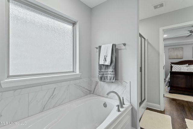 ensuite bathroom featuring visible vents, wood finished floors, ensuite bath, a shower stall, and a bath