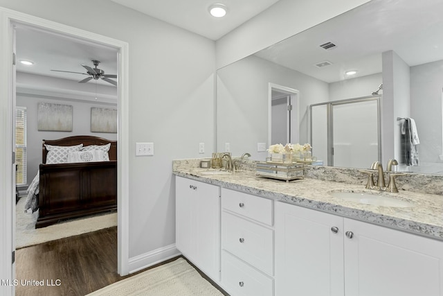 bathroom featuring a sink, visible vents, wood finished floors, and ensuite bathroom