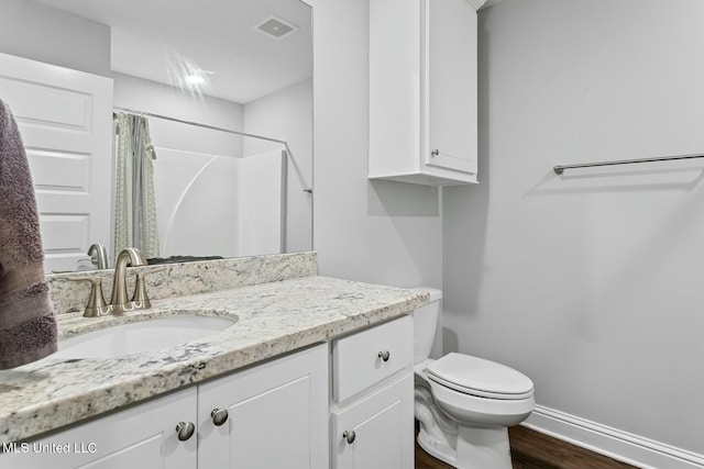 full bath with visible vents, toilet, wood finished floors, baseboards, and vanity