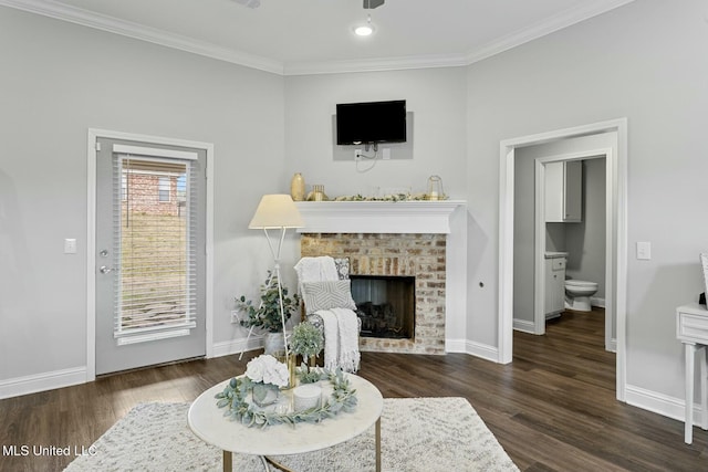 living room featuring ornamental molding, a fireplace, baseboards, and wood finished floors