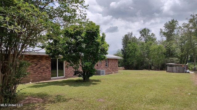 view of grassy yard featuring central AC and a jacuzzi