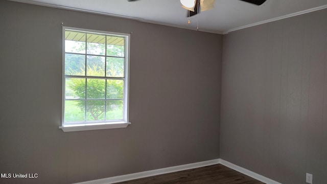 unfurnished room featuring ceiling fan, plenty of natural light, dark wood finished floors, baseboards, and ornamental molding