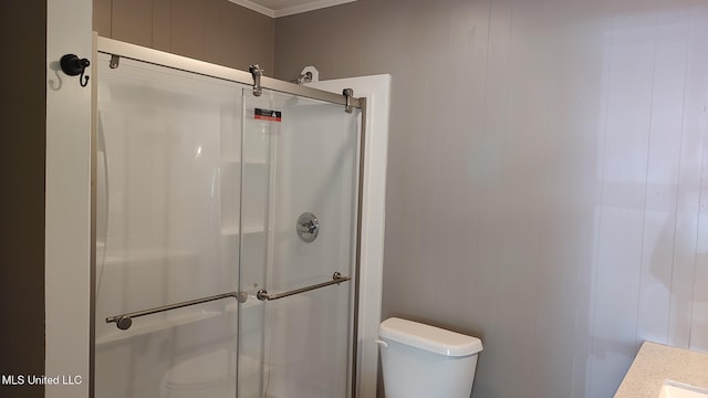full bath featuring toilet, a shower stall, and crown molding