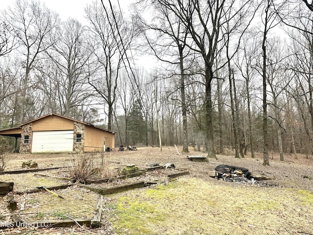 view of yard with a garage and an outbuilding