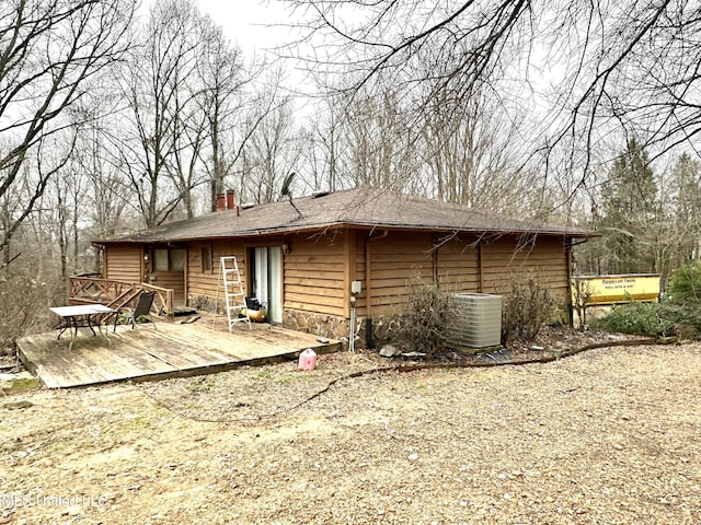 back of property with a wooden deck and central AC