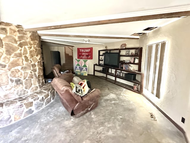 living room with beamed ceiling and concrete flooring