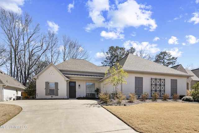 view of front of house featuring an attached garage, a shingled roof, driveway, and board and batten siding