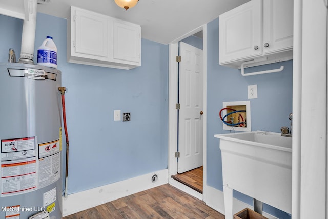 washroom featuring hookup for a washing machine, hookup for an electric dryer, water heater, cabinets, and dark hardwood / wood-style floors