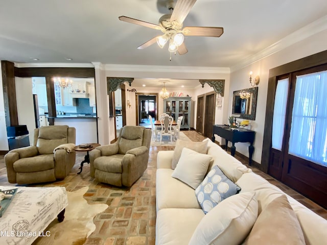 living room featuring ornamental molding and ceiling fan with notable chandelier