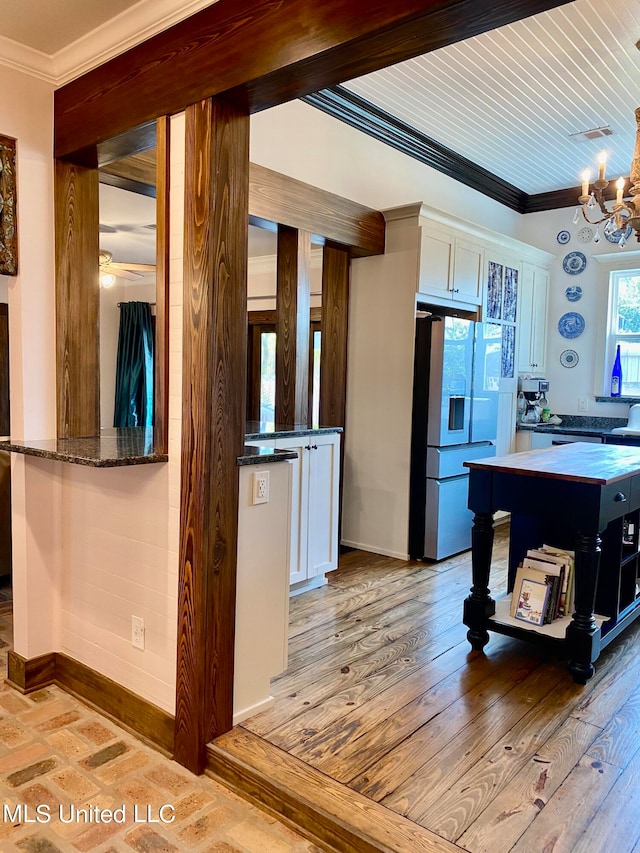 kitchen with a center island, stainless steel fridge with ice dispenser, light wood-type flooring, and white cabinetry