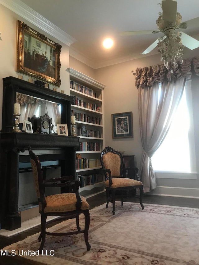 living area with ceiling fan and crown molding