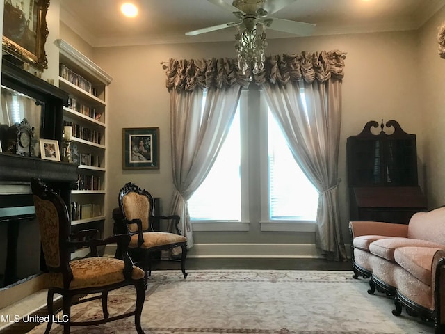 living area featuring crown molding, hardwood / wood-style floors, and ceiling fan