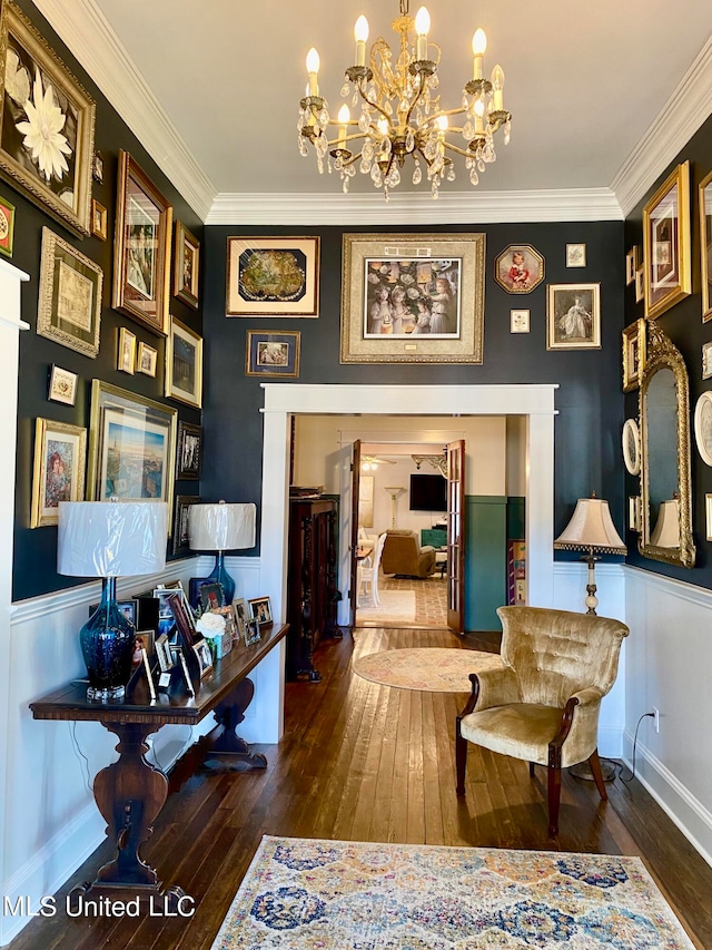 sitting room featuring ornamental molding, an inviting chandelier, and dark hardwood / wood-style floors