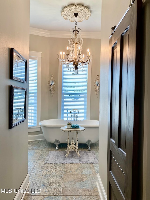 bathroom with crown molding, a notable chandelier, and a bathing tub