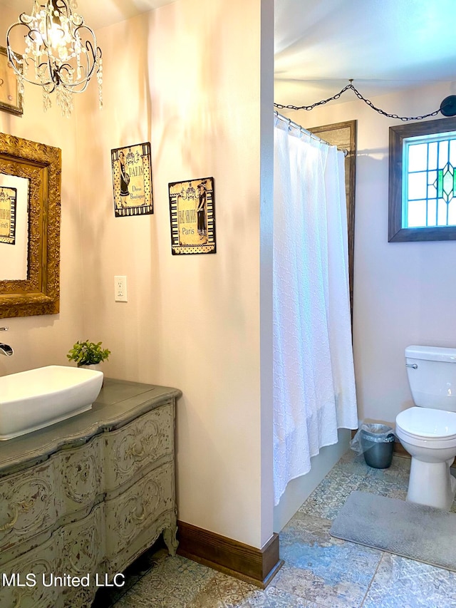 bathroom with vanity, an inviting chandelier, curtained shower, and toilet