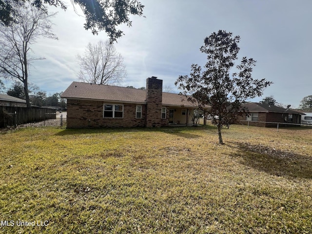 back of property featuring a yard