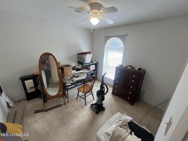 office space featuring ceiling fan, light carpet, and a textured ceiling