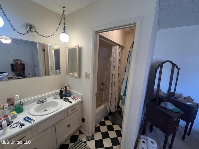 full bathroom with shower / tub combo with curtain, vanity, toilet, and a textured ceiling