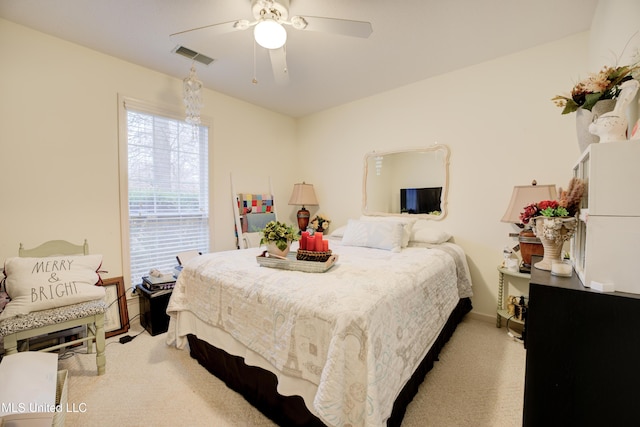 bedroom with light carpet, ceiling fan, and visible vents