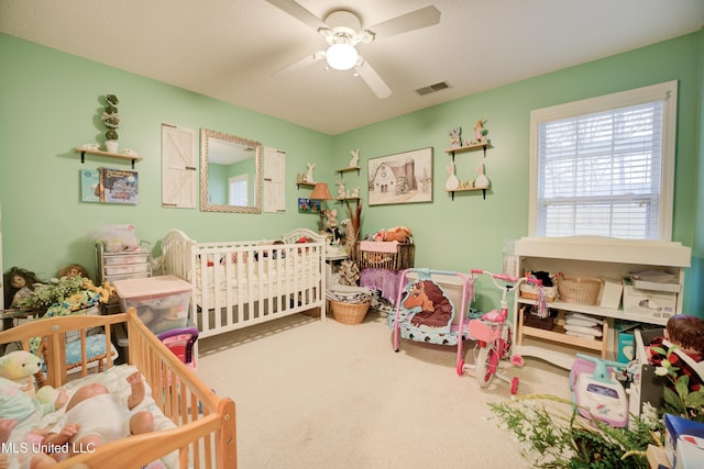 bedroom featuring a ceiling fan, visible vents, and carpet flooring