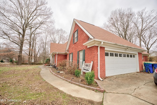 view of home's exterior with brick siding, driveway, and an attached garage