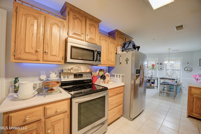 kitchen featuring light tile patterned floors, visible vents, appliances with stainless steel finishes, light countertops, and a chandelier