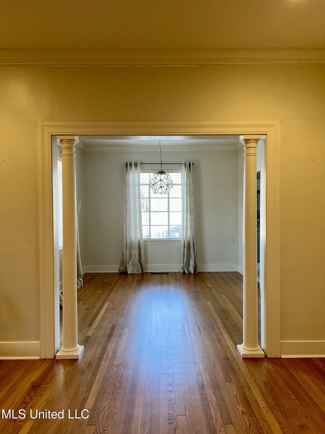 unfurnished room with ornamental molding, hardwood / wood-style floors, and ornate columns