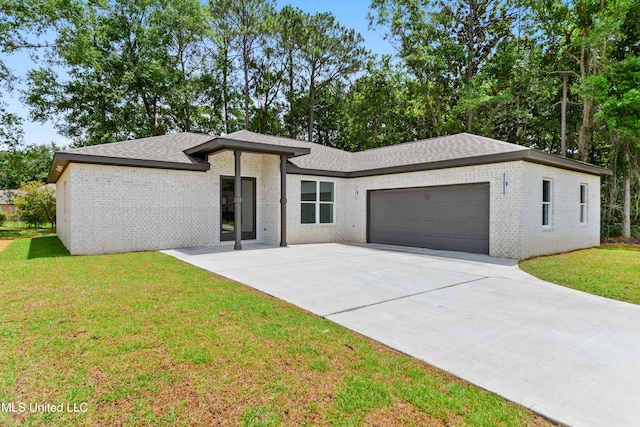 1810 Bonsecur Cv, Gautier, MS 39553 - prairie-style home featuring a garage, brick siding, a front lawn, concrete driveway, and a shingled roof