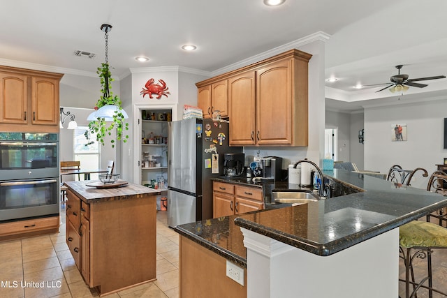 kitchen featuring sink, a kitchen island, kitchen peninsula, stainless steel appliances, and ornamental molding