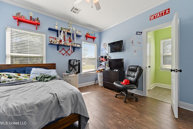 bedroom with crown molding, dark hardwood / wood-style floors, and ceiling fan