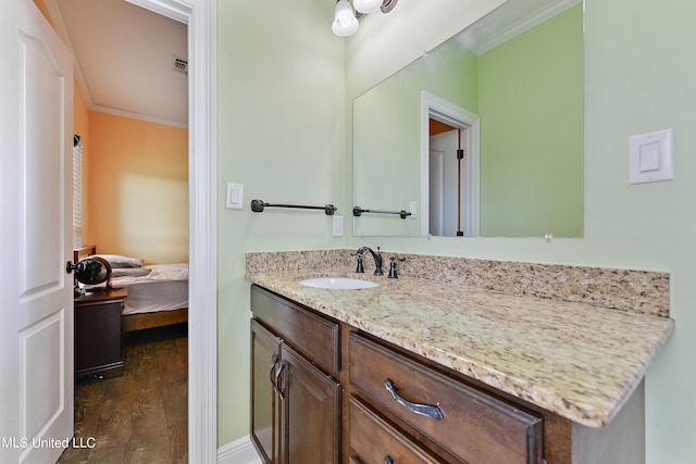 bathroom featuring vanity, ornamental molding, and wood-type flooring