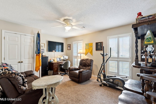 carpeted living room featuring a textured ceiling and ceiling fan