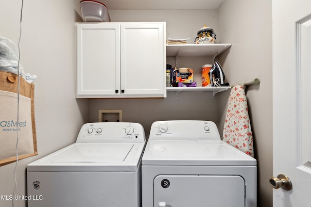 laundry area featuring washer and dryer and cabinets