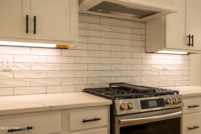 kitchen with tasteful backsplash, light stone countertops, high end stainless steel range, and extractor fan