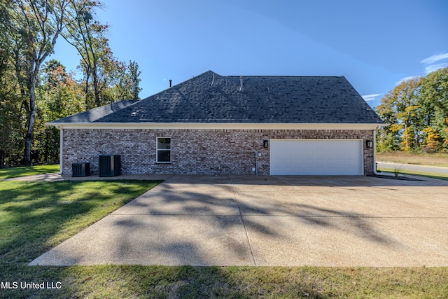 view of property exterior featuring central air condition unit, a yard, and a garage