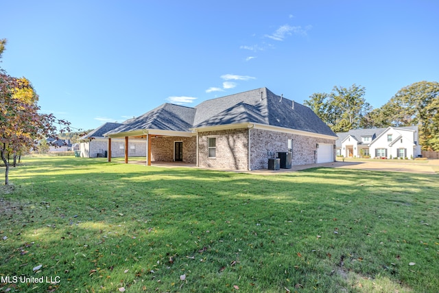 rear view of property with cooling unit, a garage, and a yard