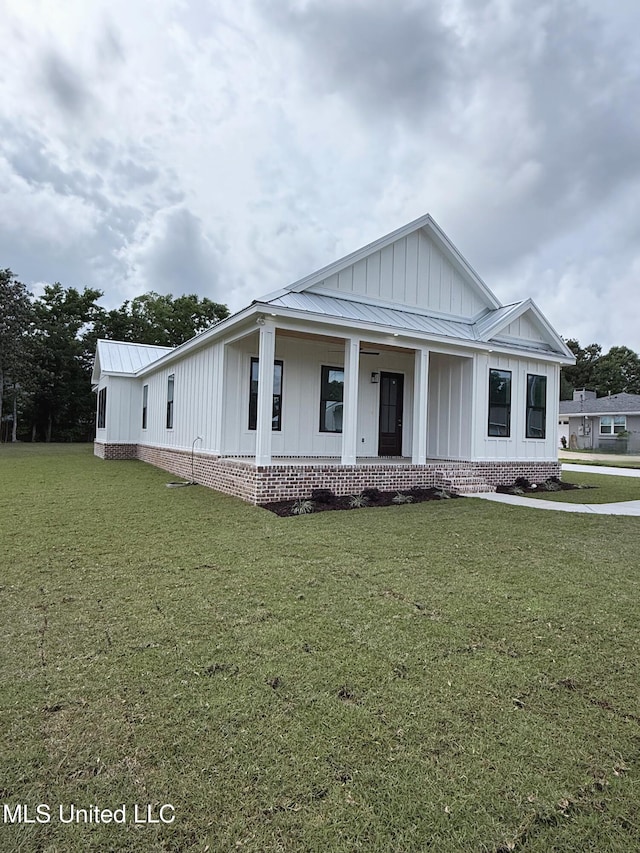 217 White Harbor Rd, Long Beach, MS 39560 - view of front of property featuring a porch, a front lawn, board and batten siding, and metal roof