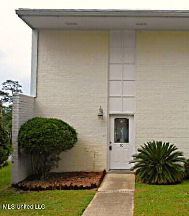 property entrance with a lawn