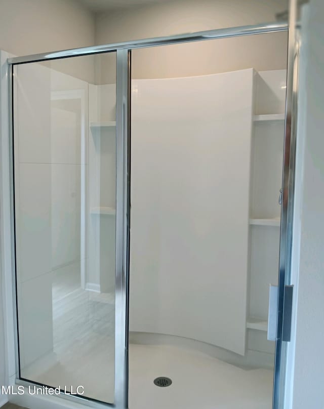 bathroom featuring a shower with shower door