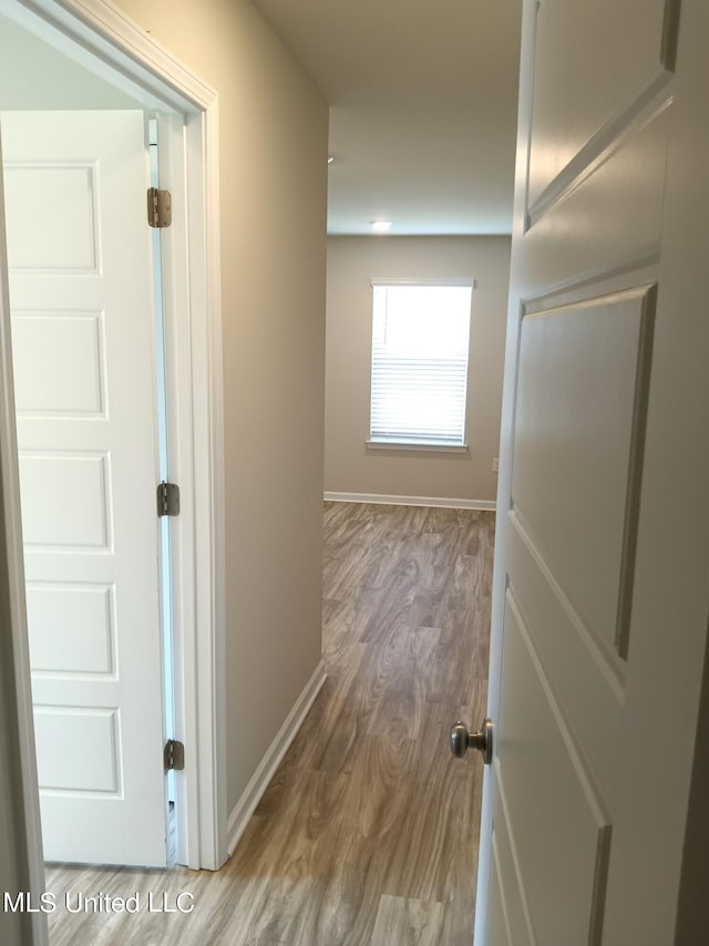 hallway with hardwood / wood-style floors