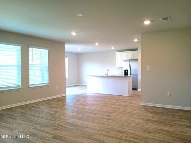 unfurnished living room with sink and hardwood / wood-style floors