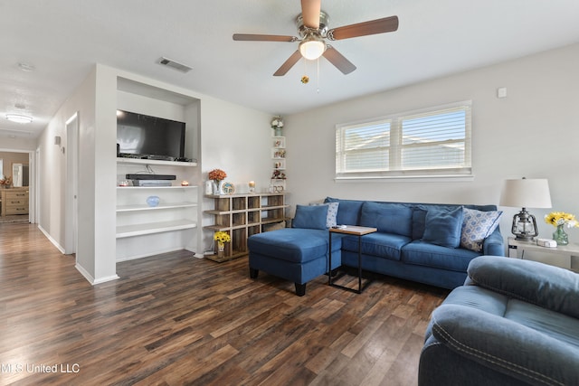 living room featuring ceiling fan and dark wood-type flooring