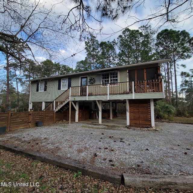 view of front of house with a carport, driveway, stairs, and a deck