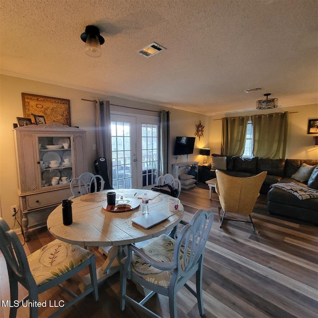 dining area with visible vents, a textured ceiling, and dark wood finished floors