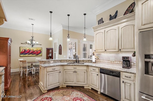 kitchen with a peninsula, a sink, ornamental molding, stainless steel appliances, and cream cabinetry